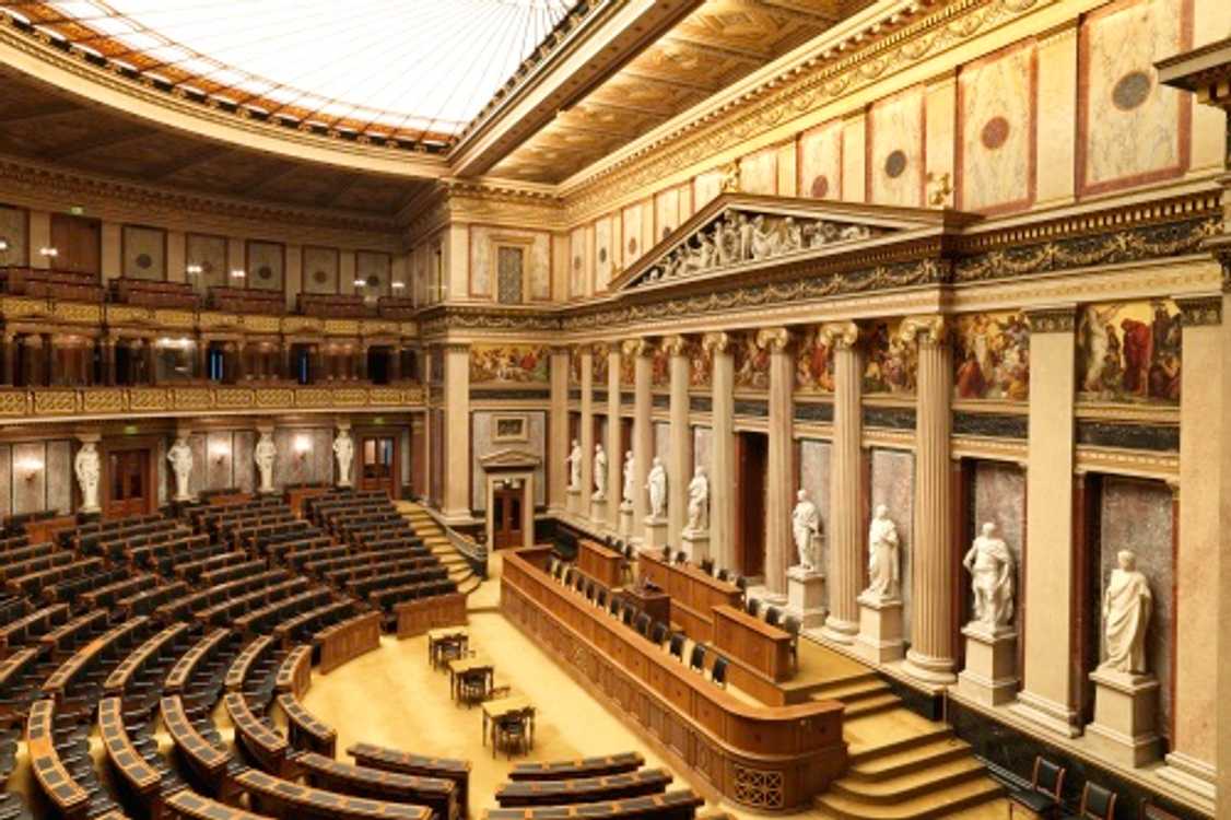 Aktuální stav historické sněmovny, kterou dnešní rakouský parlament využívá při výjimečných okolnostech ke společným zasedáním svých dvou komor. Patrná je bohatá výzdoba sálu, stejně jako prosklený strop pouštící do sálu denní světlo.