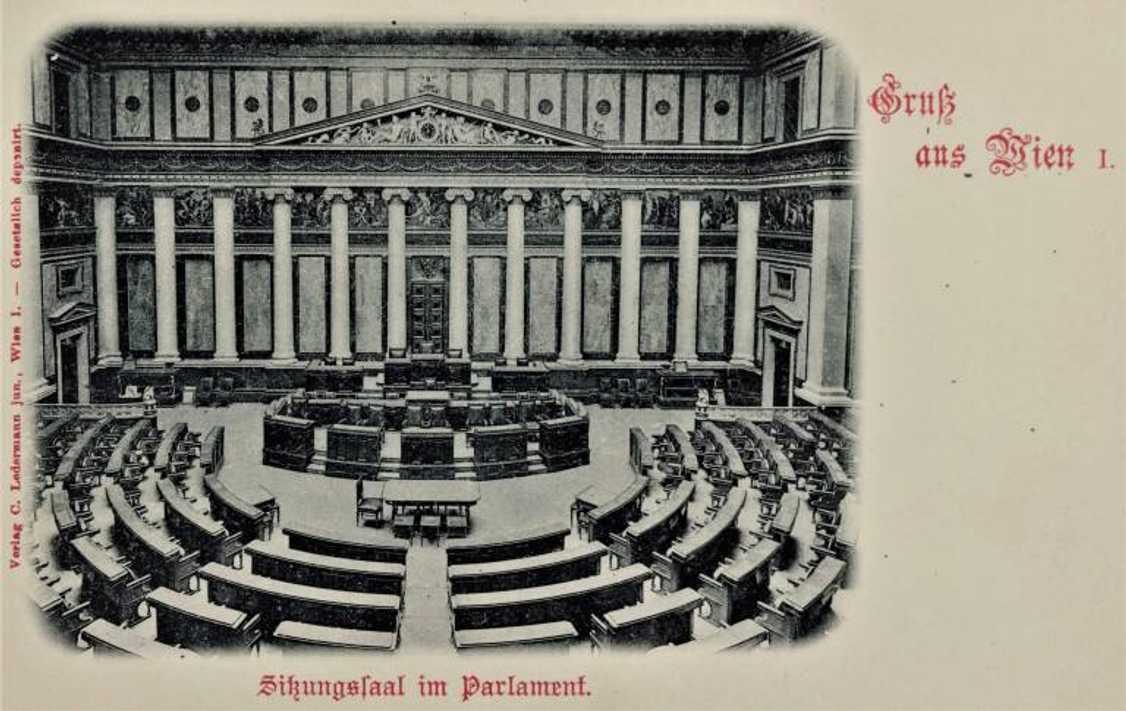 Dobová pohlednice směrem k prezidiu sněmovny, dobře patrné jsou zejména místa ministrů a před nimi stůl určený sněmovním stenografům.